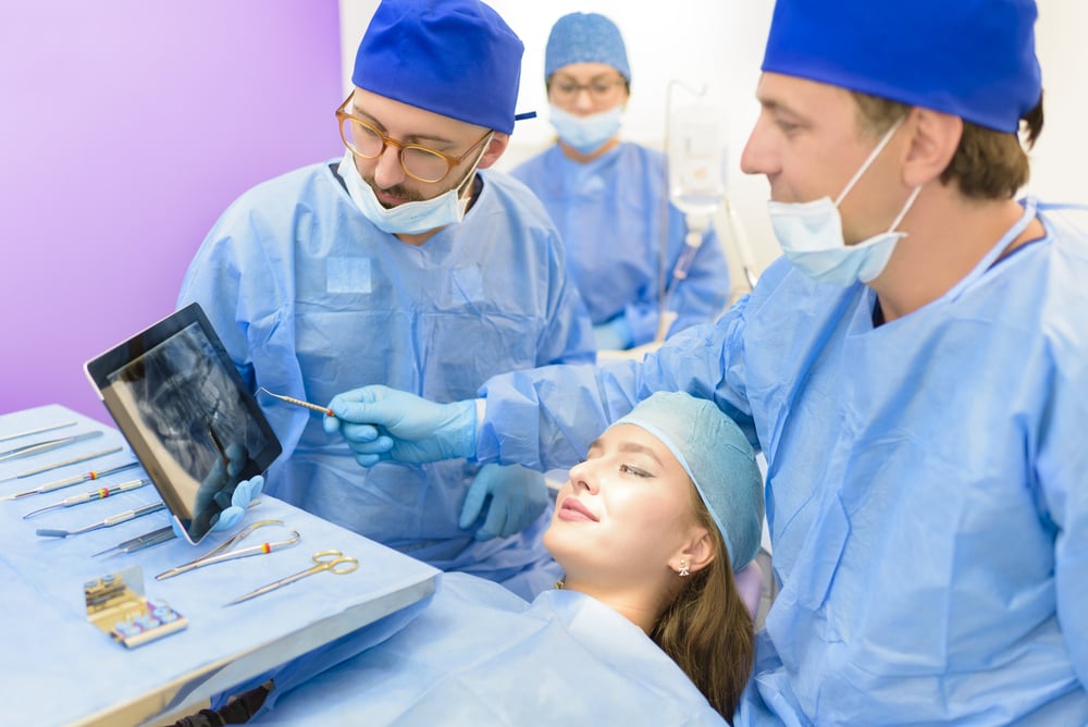 Oral Surgeons explaining radiography to young woman patient