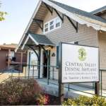 Building entrance: sign reads “Central Valley Dental Implant & Oral Surgery Institute, Dr. Timothy J. Rennell, D.D.S.”; ramp and shrubs visible