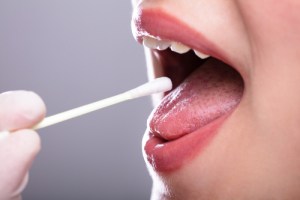 child having a cotton swab placed in mouth