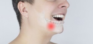 Schematic representation of pain in the jaw. Augmented reality. An x-ray of the jaw bone superimposed on a photograph. Painful areas are highlighted in red.